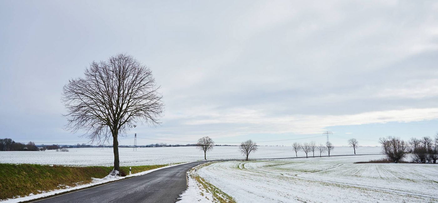 Zimowy krajobraz – droga wśród zaśnieżonych pól